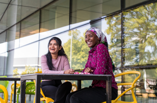 Two women sitting at a table
AI-generated content may be incorrect.